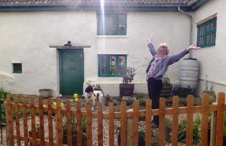 Image-of-a-happy-customer-nikki-standing-by-the-discreet-high-quality-below-ground-WPL-Diamond-package-wastewater-sewage-treatment-pant-for-off-mains-drainage- at-a-beautiful-cottage-in-the-uk-the-wpl-diamond-replaced-a-leaking-septic-tank.